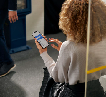 mulher em metro mexendo em celular