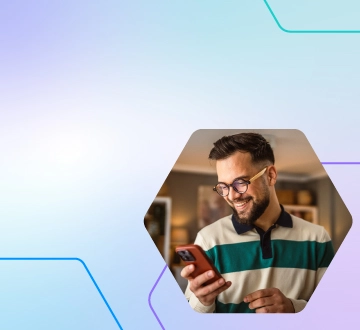 Foto de homem sorrindo enquanto olha celular.